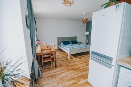 ein Wohnzimmer mit einem Bett und einem Tisch sowie eine Küche in der Unterkunft City center Appartment in Valmiera