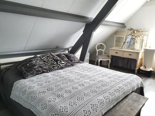 a bedroom with a white bed and a dresser at Bed en Breakfast Het Friesche Paard in Purmer