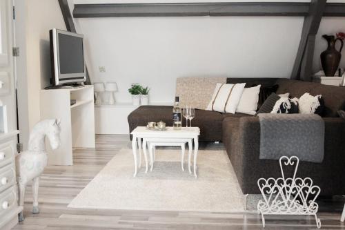 a living room with a couch and a table at Apartment Het Friesche Paard in Purmer