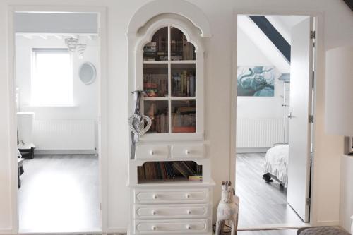 a bedroom with a white cabinet and a bed at Bed en Breakfast Het Friesche Paard in Purmer