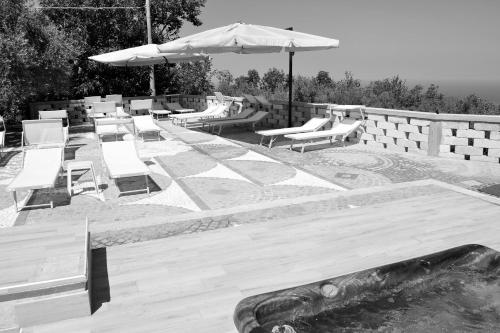 a group of benches with an umbrella and a playground at Green Park Hotel & Residence in Bagnara Calabra
