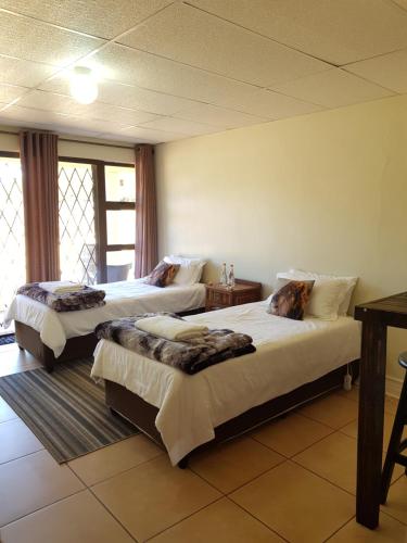 Habitación de hotel con 2 camas y ventana en CHEETAH MANOR #2 en Bloemfontein