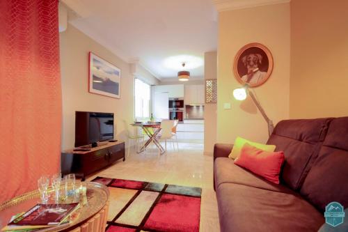 un salon avec un canapé et une télévision dans l'établissement Annecy Lake - Le Saint Bernard - 2 min walk from the lake, à Annecy