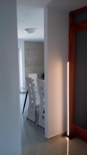 a dining room with white chairs and a table at Káli Apartman in Bakonybél