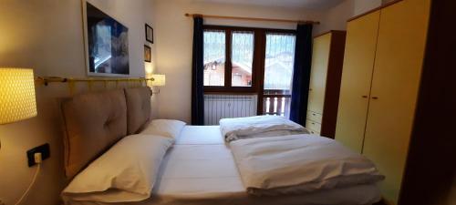 two beds in a room with a window at Residence Weissthor in Macugnaga