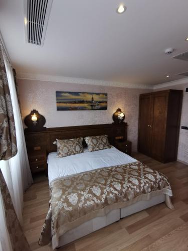 a bedroom with a large bed and two lights at Perapolis Hotel in Istanbul