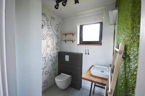a bathroom with a white toilet and a sink at Siedlisko Ciemno in Ciemno