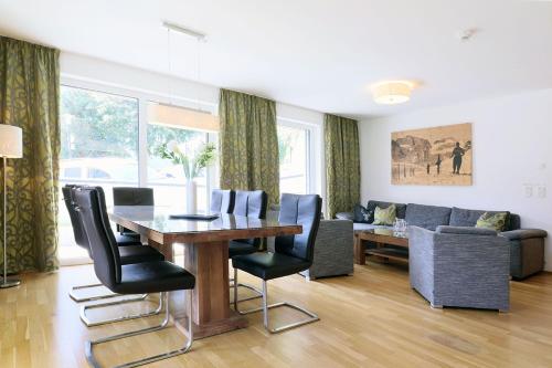 a living room with a table and chairs and a couch at Alpin & See Resort - Pinzgau Holidays in Zell am See