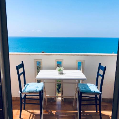 a table and two chairs with a view of the ocean at Apartment Marechiaro Agrigento in Zingarello