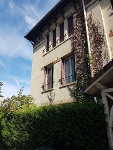 a building with windows and vines on the side of it at L'AUBERGADE Bis in Vittel