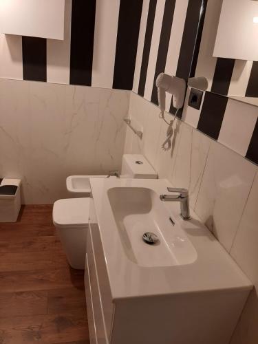 a white bathroom with a sink and a toilet at Suite il sogno di Grebek in Passo del Tonale