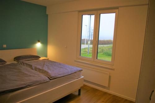 a bedroom with a bed and a window at Witt am See L in Klein Wittensee