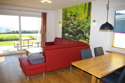 a living room with a red couch and a table at Witt am See L in Klein Wittensee