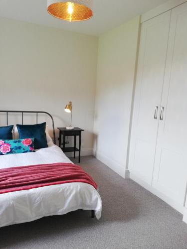 a bedroom with a large bed with blue pillows at Next door at Broomfield House in Midleton