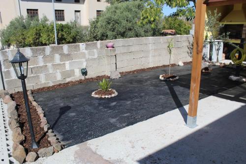 a courtyard with a retaining wall and two potted plants at "Sutt'e su sole" - Vacanza nel cuore della Sardegna in Siamanna