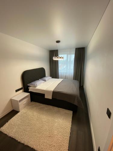 - une petite chambre avec un lit et un tapis dans l'établissement Parko 443, à Panevėžys