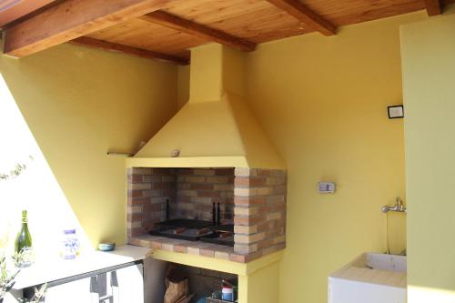 a fireplace in a room with a yellow wall at "Sutt'e su sole" - Vacanza nel cuore della Sardegna in Siamanna