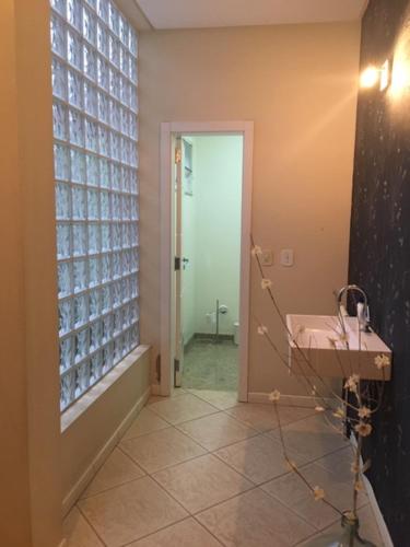 a hallway with a bathroom with a sink and a door at Pousada Benedicto in Benedito Novo