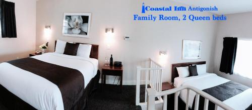 a hotel room with two beds and a staircase at Coastal Inn Antigonish in Antigonish