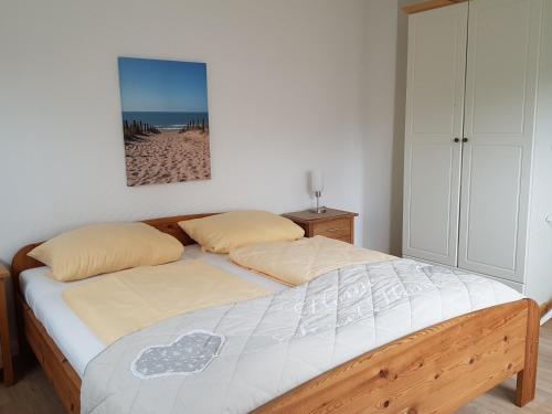 a bedroom with a bed with a picture of a beach at Ferienhaus Pilsum in Krummhörn