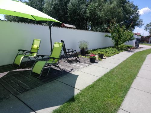 a group of chairs and an umbrella on a sidewalk at Sarkcsillag Vendégház in Kiskőrös