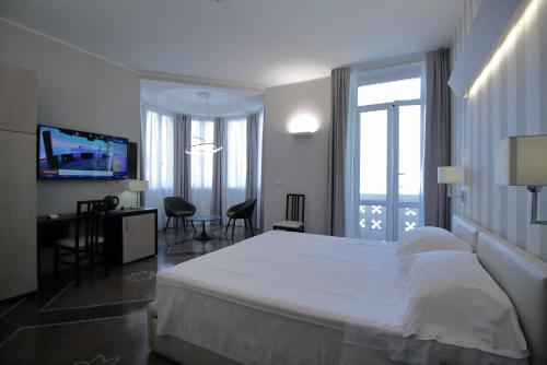 Habitación de hotel con cama y TV en Hotel Vittoria en Génova