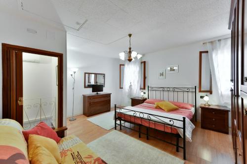 1 dormitorio con cama y espejo en BRUNA HOLIDAYS HOUSE, en Burano