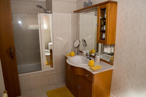 uma casa de banho com um lavatório e um chuveiro em ZiZis Place em Santa Cruz - Madeira