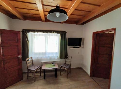 a room with a table and chairs and a window at Kishíd Vendégház Pilismarót in Pilismarót