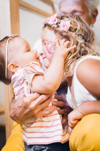 a woman holding a child with her face painted at Biancaneve Family Hotel in Selva di Val Gardena