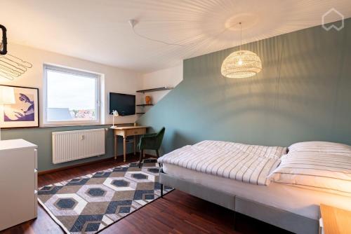 een slaapkamer met een bed, een bureau en een televisie bij 110qm Countryside Loft in Neufahrn in Niederbayern