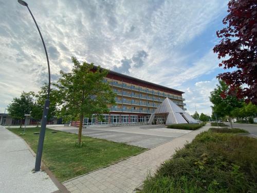 a large building with a tree in front of it at Kurhotel Pyramide Bad Windsheim in Bad Windsheim