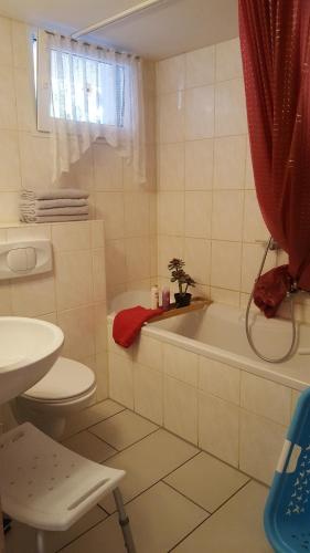 a bathroom with a tub and a toilet and a sink at Am Berg-Ferienwohnung in Ettal