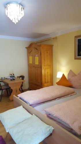 埃塔爾的住宿－Am Berg-Ferienwohnung，一间卧室配有两张床、一张桌子和一个吊灯。