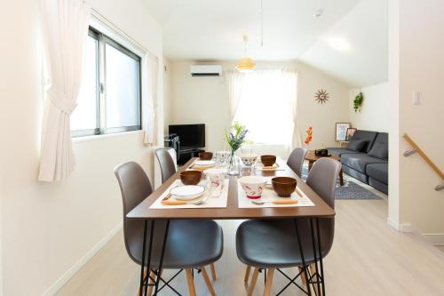 een eetkamer en een woonkamer met een tafel en stoelen bij 足跡 ASHIATO in Tokyo
