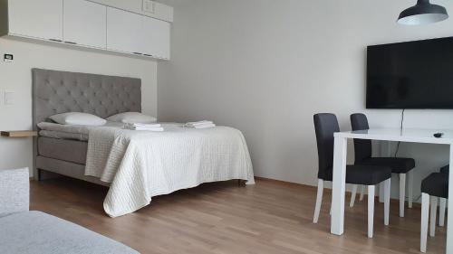 um quarto com uma cama, uma mesa e uma televisão em Toimiva uusi yksiö keskustassa em Turku