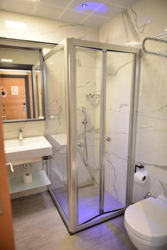 a bathroom with a shower and a toilet and a sink at Oasis Hotel in Marmaris