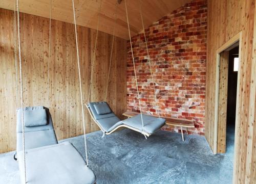 a room with two chairs and a brick wall at Hotel Neusacherhof in Weissensee
