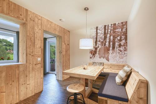 a dining room with a table and a bench at Nockberge Lodge in Bad Kleinkirchheim