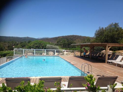 une grande piscine sur une terrasse en bois dans l'établissement Villa Les Hameaux Di Santa Giulia, à Porto-Vecchio