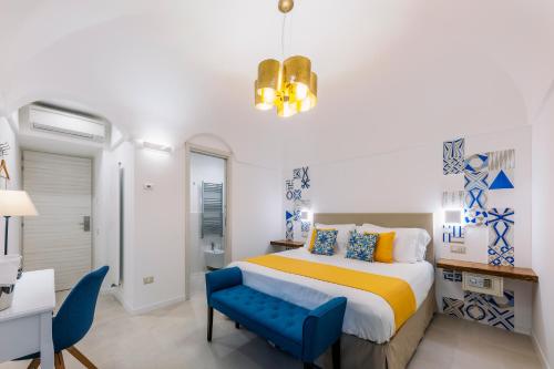um quarto com uma cama e uma cadeira azul em Monte Brusara Relais em Ravello