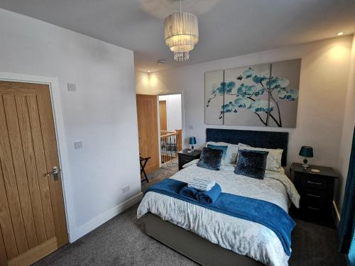 1 dormitorio con cama y lámpara de araña en Saracens House en Preesall