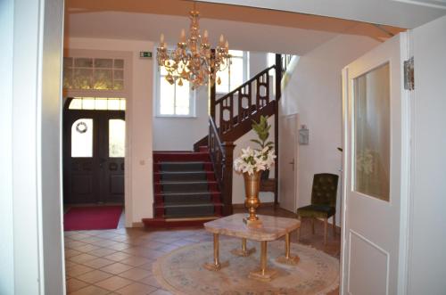 a living room filled with furniture and a staircase at Hotel zur Köppe in Bad Klosterlausnitz