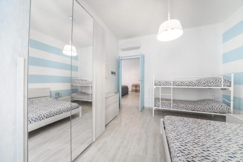 1 dormitorio con 2 camas y espejo en Gli appartamenti della Fra, en Lavagna