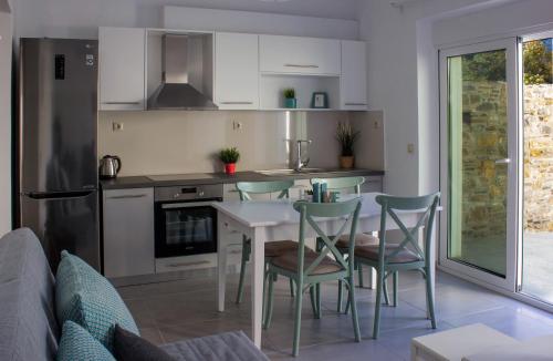 a kitchen with a table and chairs in a kitchen at New and Airy Apartment few steps from the beach in Sougia