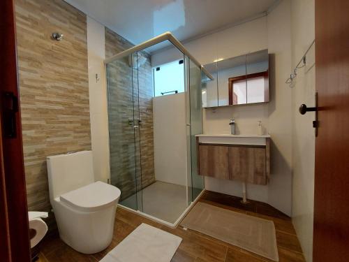 La salle de bains est pourvue de toilettes et d'une douche en verre. dans l'établissement San Michael Hospedaria, à Treze Tílias