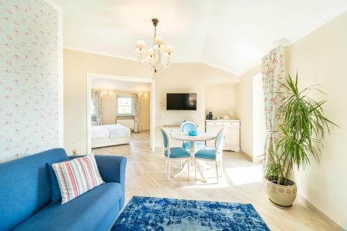 Una sala de estar con un sofá azul y una mesa. en Borgo Vecchio Locanda di Charme, en Neive