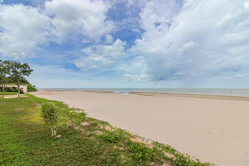 a sandy beach with trees and the ocean at Munlihouse Cha-Am Hua-Hin Beach in Cha Am