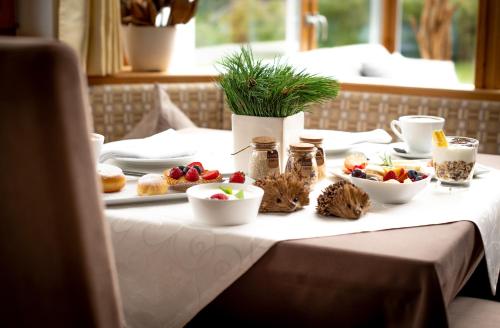 einen Tisch mit einem weißen Tischtuch mit Essen drauf in der Unterkunft Garni Sunela B&B in Wolkenstein in Gröden