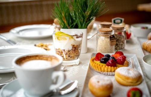 Una mesa con una taza de café y un plato de comida. en Garni Sunela B&B, en Selva di Val Gardena